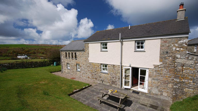 The exterior and garden of Zennor Honor's House, with lawn and patio with picnic bench, Cornwall